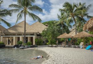 person lying on sand near sea