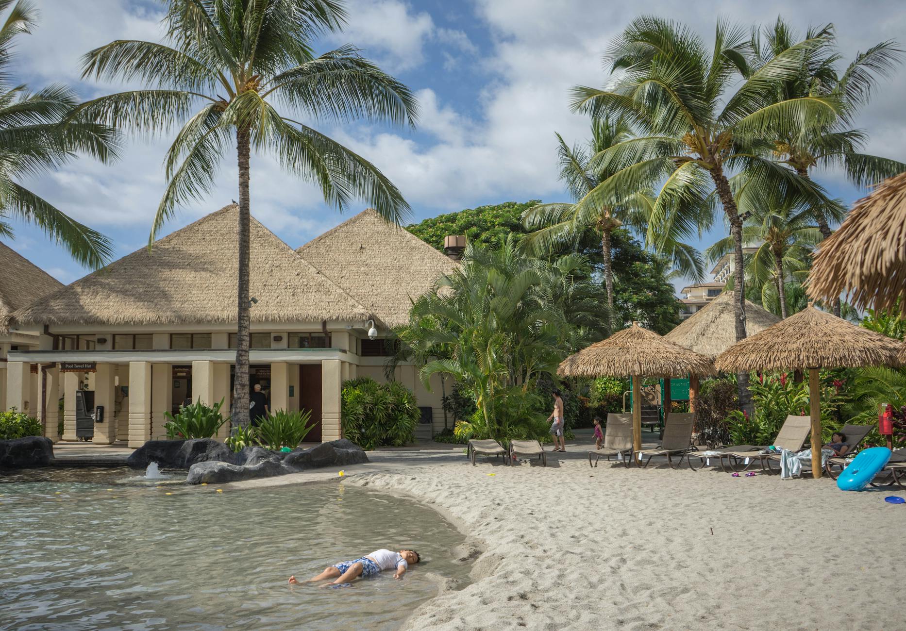 person lying on sand near sea
